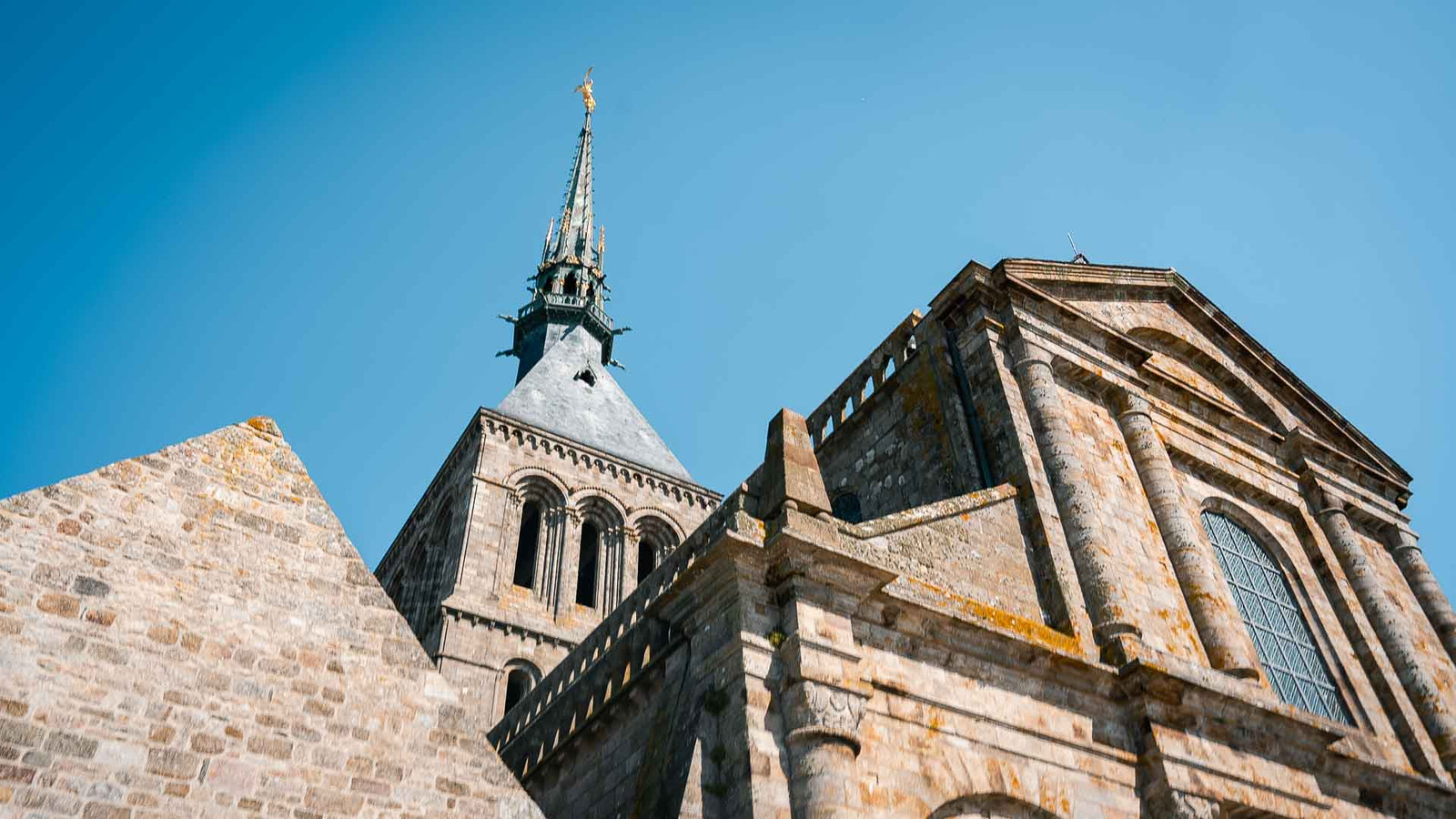 Saint Michael slaying the dragon at the top of the Mont St Michel abbey spire
